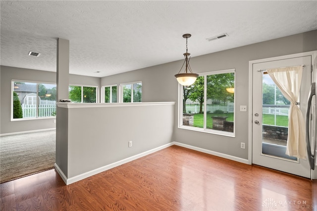 2750 Twin Lakes Dr, Troy, OH 45373 - unfurnished dining area with plenty of natural light, wood finished floors, baseboards, and a textured ceiling