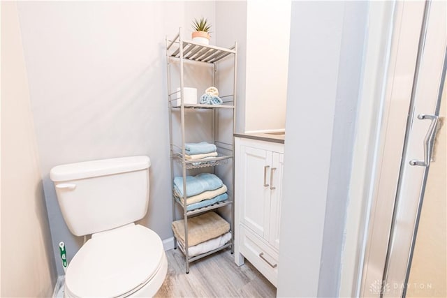 10125 Seminole Shore Dr, Huntsville, OH 43324 - bathroom with toilet, baseboards, and wood finished floors