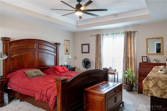 bedroom featuring crown molding, a ceiling fan, a tray ceiling, and carpet