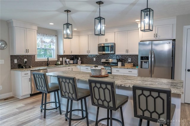 kitchen featuring a sink, light wood-style flooring, white cabinets, and stainless steel appliances