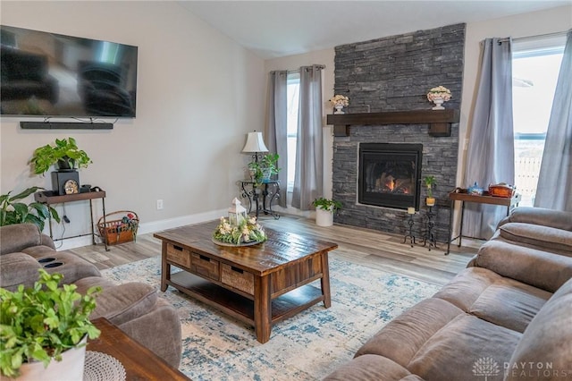 living area featuring baseboards, wood finished floors, lofted ceiling, and a fireplace