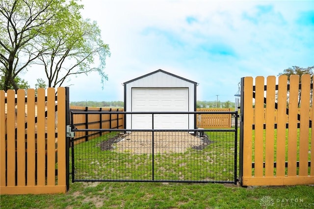 view of gate with fence, an outbuilding, and a yard