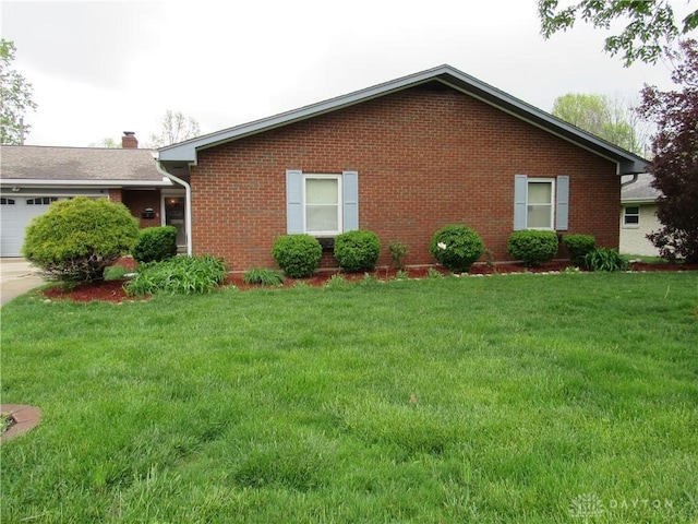 view of property exterior featuring a lawn, brick siding, an attached garage, and driveway