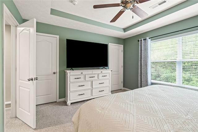 4266 Straight Arrow Rd, Beavercreek, OH 45430 - bedroom with a ceiling fan, light colored carpet, visible vents, baseboards, and a tray ceiling