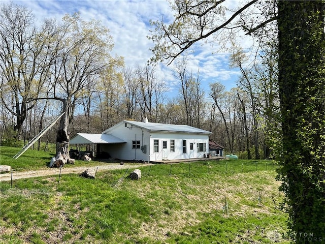 view of front of home featuring a wooden deck, a chimney, and a front lawn