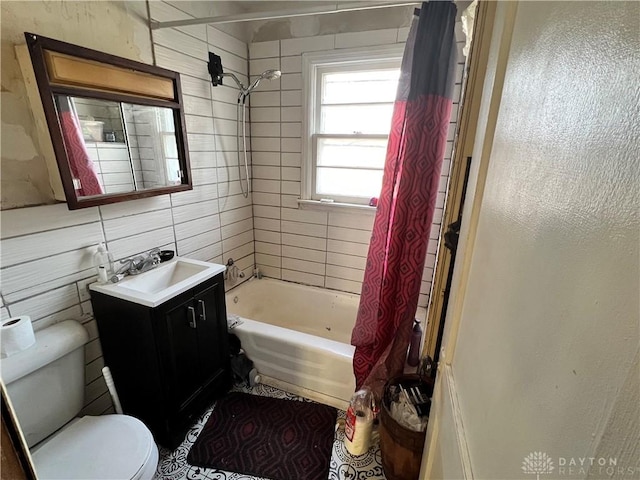 full bath with vanity, toilet, shower / bathtub combination with curtain, and tile walls