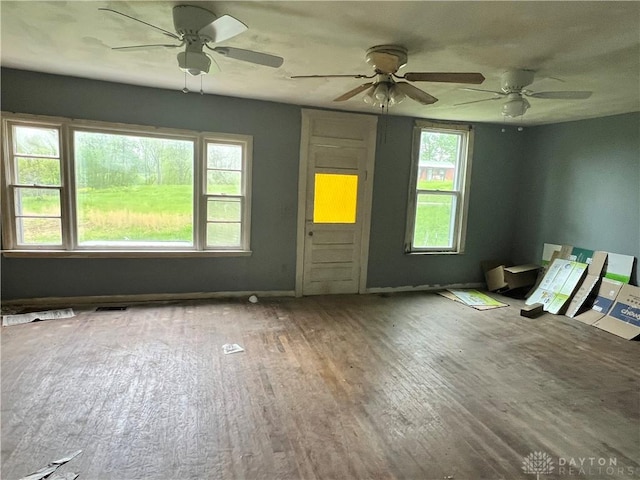 unfurnished room with visible vents, wood finished floors, and ceiling fan