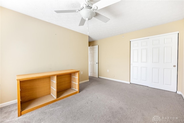 unfurnished bedroom with a ceiling fan, carpet floors, baseboards, and a closet