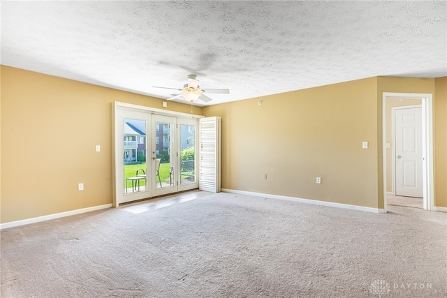carpeted empty room with ceiling fan, a textured ceiling, and baseboards