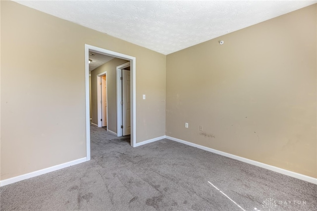 carpeted empty room featuring baseboards