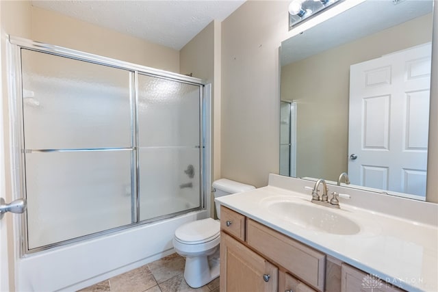 bathroom with toilet, vanity, and combined bath / shower with glass door