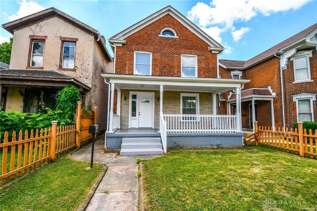 221 Linden Ave, Dayton, OH 45403 - traditional-style home featuring covered porch, brick siding, a front lawn, and fence