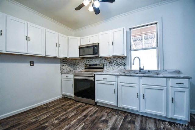 221 Linden Ave, Dayton, OH 45403 - kitchen featuring a sink, dark wood finished floors, backsplash, appliances with stainless steel finishes, and ornamental molding