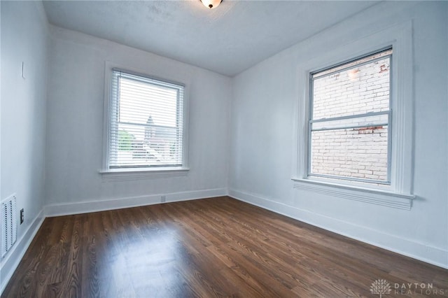 221 Linden Ave, Dayton, OH 45403 - unfurnished room featuring baseboards, dark wood finished floors, and visible vents
