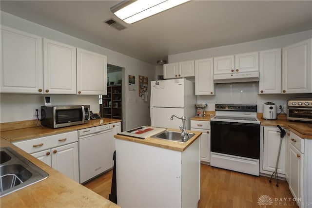 kitchen with a sink, white appliances, under cabinet range hood, and white cabinets
