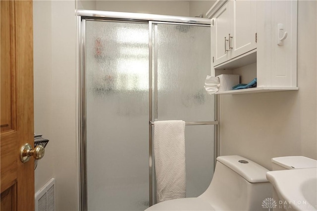 full bath featuring toilet, visible vents, and a shower stall