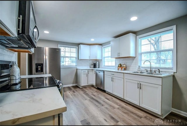 2004 N Reardon Dr, Dayton, OH 45420 - kitchen with white cabinetry, appliances with stainless steel finishes, tasteful backsplash, and a sink