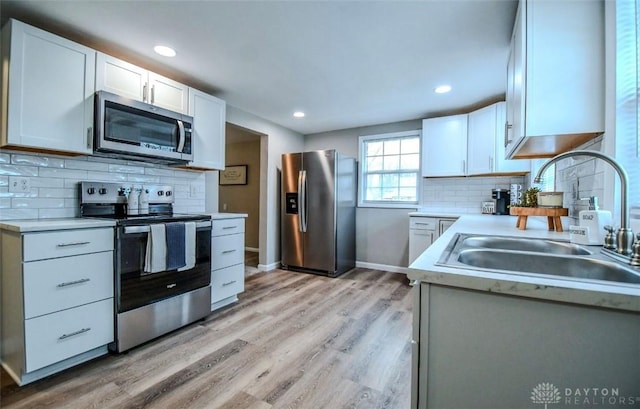 2004 N Reardon Dr, Dayton, OH 45420 - kitchen featuring light wood-style flooring, a sink, stainless steel appliances, white cabinets, and light countertops