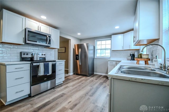 2004 N Reardon Dr, Dayton, OH 45420 - kitchen with light countertops, light wood-style floors, stainless steel appliances, and a sink