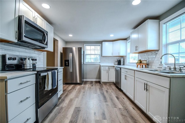 2004 N Reardon Dr, Dayton, OH 45420 - kitchen with light wood finished floors, appliances with stainless steel finishes, tasteful backsplash, and a sink