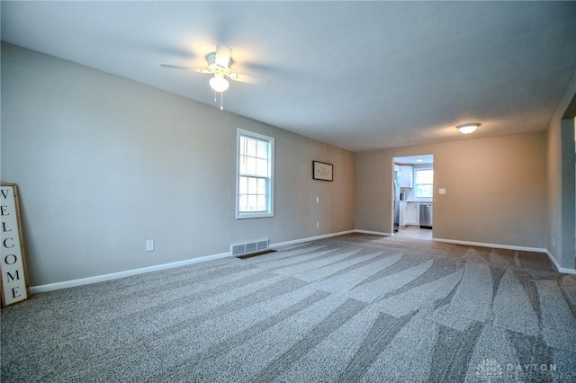 2004 N Reardon Dr, Dayton, OH 45420 - carpeted empty room with visible vents, baseboards, a ceiling fan, and a healthy amount of sunlight