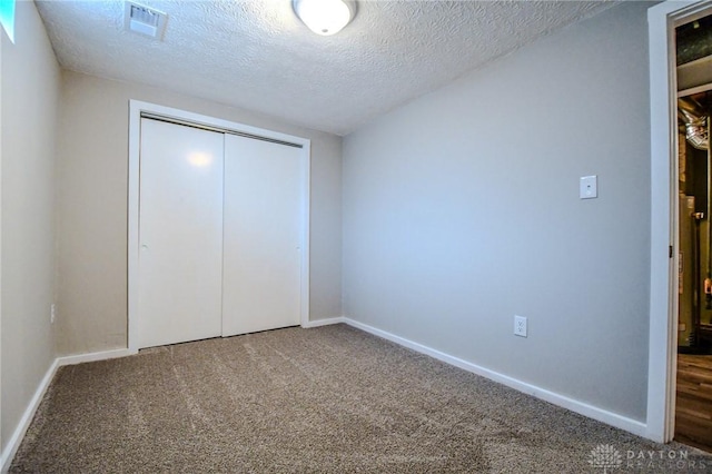2004 N Reardon Dr, Dayton, OH 45420 - unfurnished bedroom with a textured ceiling, carpet floors, a closet, and baseboards