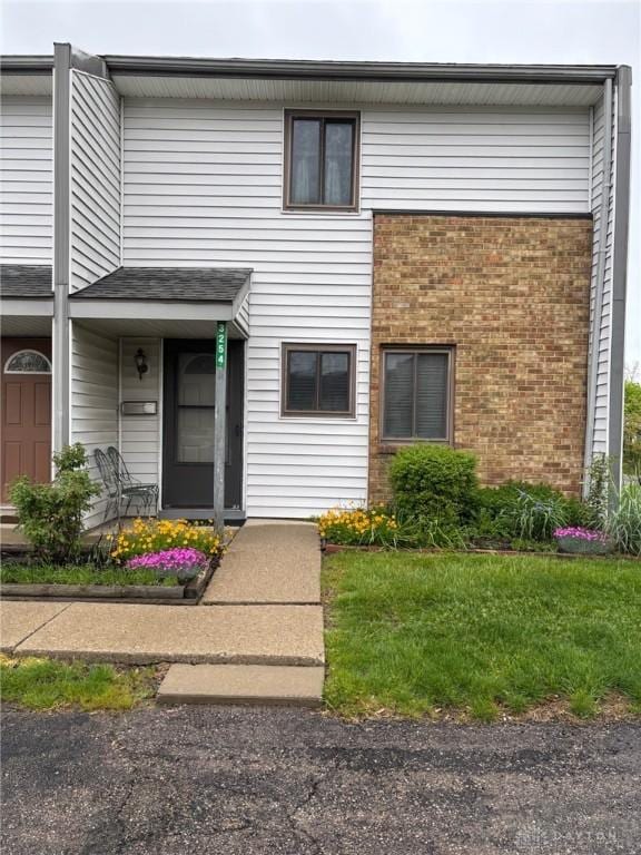 townhome / multi-family property featuring brick siding and a front yard