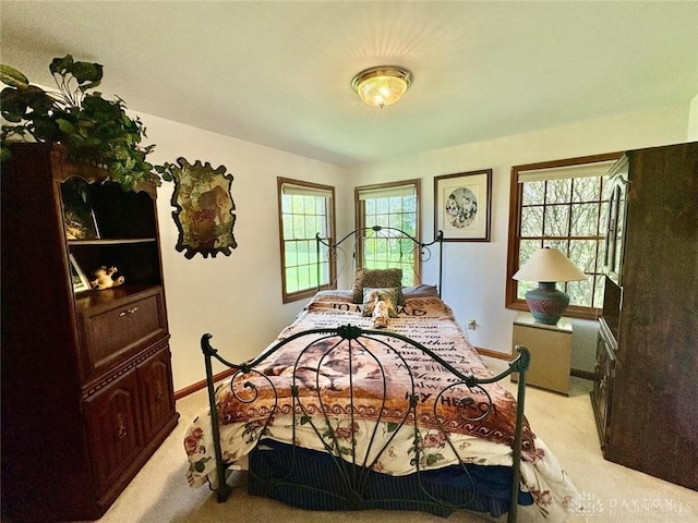 bedroom featuring light colored carpet and baseboards