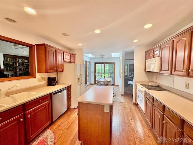 kitchen featuring a sink, ceiling fan, white appliances, and light wood finished floors