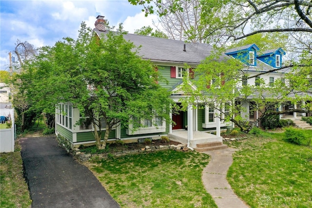 825 Far Hills Ave, Oakwood, OH 45419 - view of front of house with a chimney, a front lawn, and driveway