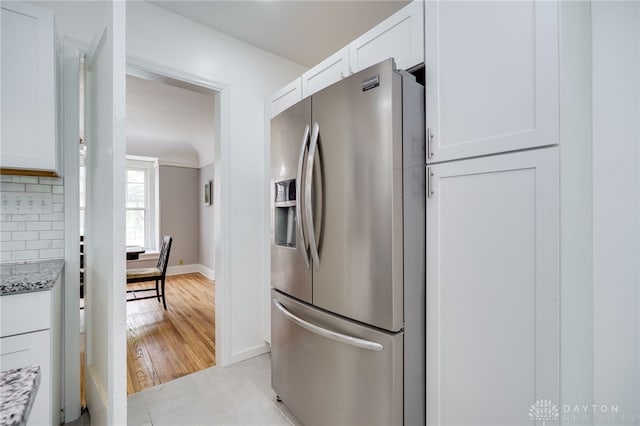 825 Far Hills Ave, Oakwood, OH 45419 - kitchen with stainless steel fridge with ice dispenser, white cabinets, light stone countertops, baseboards, and backsplash