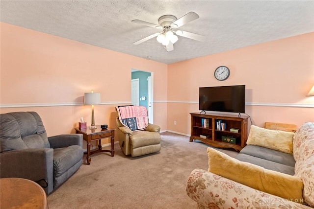 carpeted living room featuring ceiling fan, a textured ceiling, and baseboards