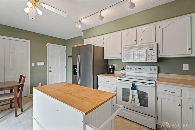 1579 Commonwealth Dr, Xenia, OH 45385 - kitchen with white appliances, white cabinetry, light flooring, and a ceiling fan
