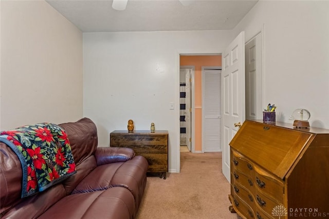 living area with ceiling fan and light colored carpet