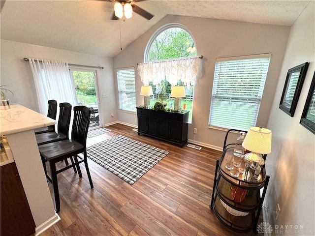office with wood finished floors, visible vents, vaulted ceiling, a ceiling fan, and baseboards