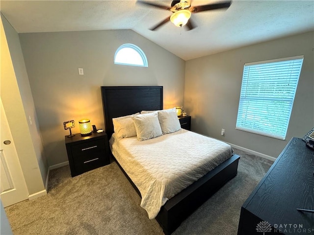 bedroom with vaulted ceiling, light colored carpet, baseboards, and ceiling fan