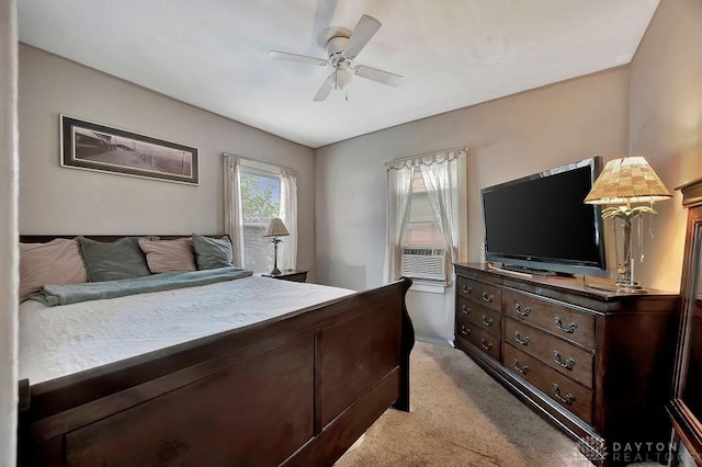 bedroom with ceiling fan, light carpet, and cooling unit