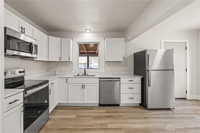709 E Dorothy Ln, Dayton, OH 45419 - kitchen featuring a sink, stainless steel appliances, light wood-type flooring, light countertops, and white cabinets