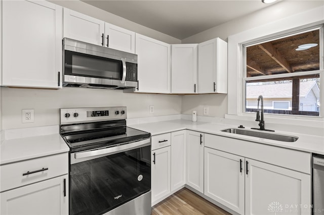 709 E Dorothy Ln, Dayton, OH 45419 - kitchen with a sink, stainless steel appliances, white cabinetry, and light countertops