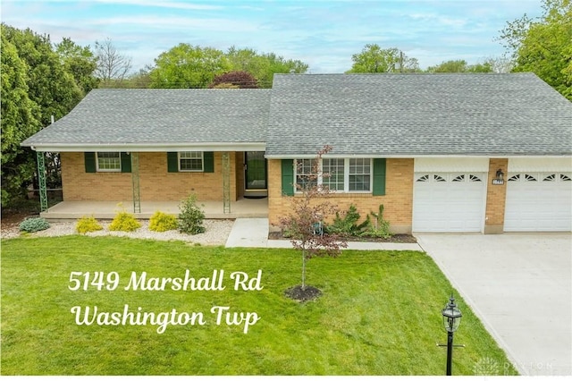 5149 Marshall Rd, Washington Twp, OH 45429 - view of front of house featuring driveway, brick siding, a garage, covered porch, and a shingled roof
