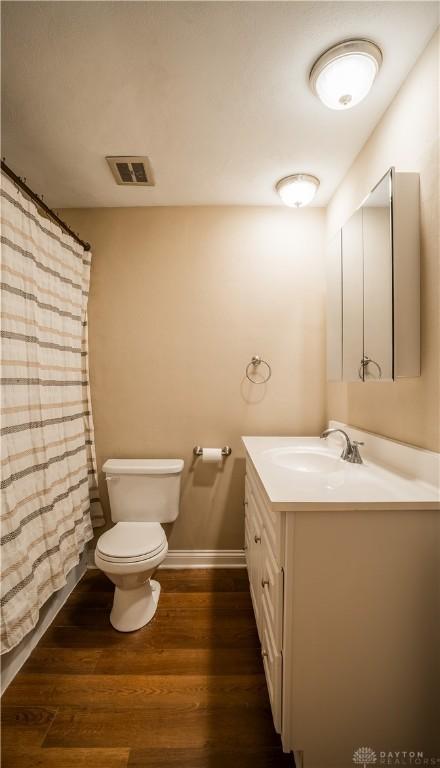 5149 Marshall Rd, Washington Twp, OH 45429 - full bathroom featuring vanity, toilet, wood finished floors, and a shower with curtain