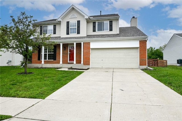 traditional-style home with fence, brick siding, driveway, a front yard, and a chimney