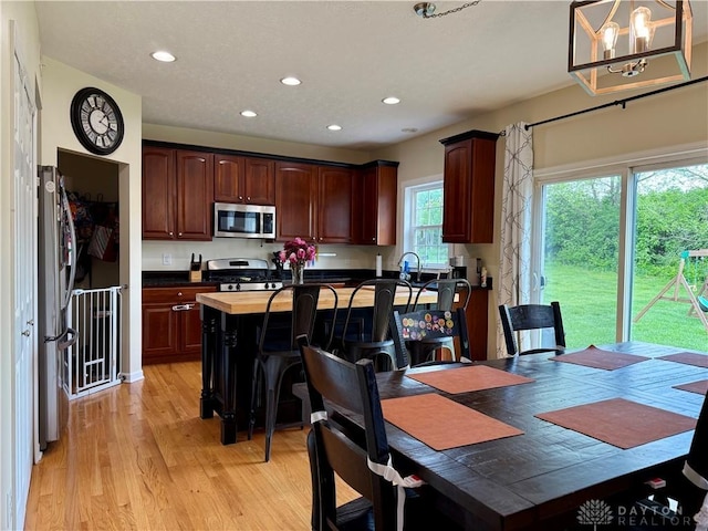 dining room featuring light wood finished floors, a notable chandelier, and recessed lighting