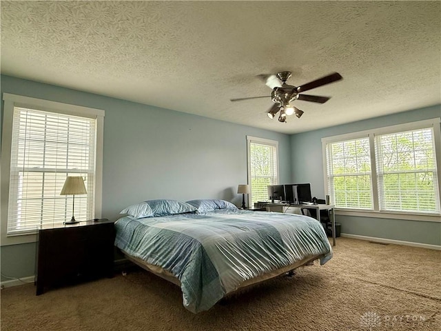 bedroom featuring a ceiling fan, a textured ceiling, carpet, baseboards, and visible vents