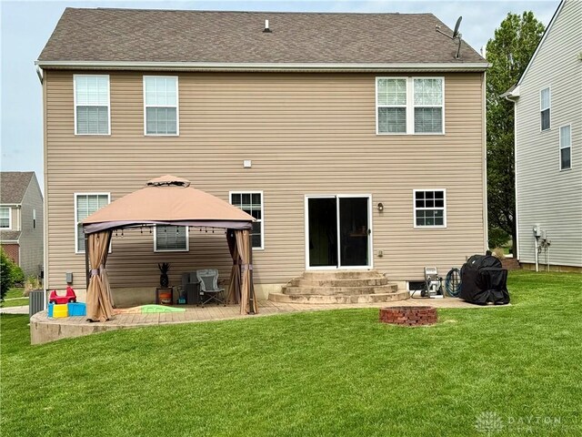 back of property featuring a lawn, a patio, a gazebo, and entry steps