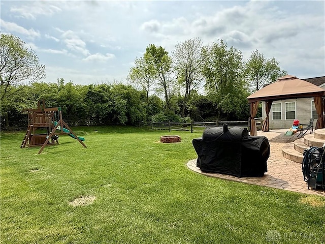 view of yard featuring a gazebo, a patio, a fenced backyard, an outdoor fire pit, and a playground