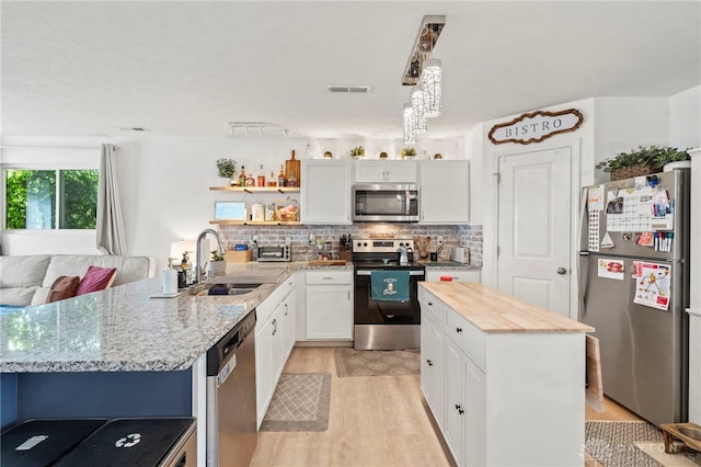 784 Marshall Dr, Xenia, OH 45385 - kitchen with appliances with stainless steel finishes, a sink, light wood-type flooring, white cabinetry, and open shelves
