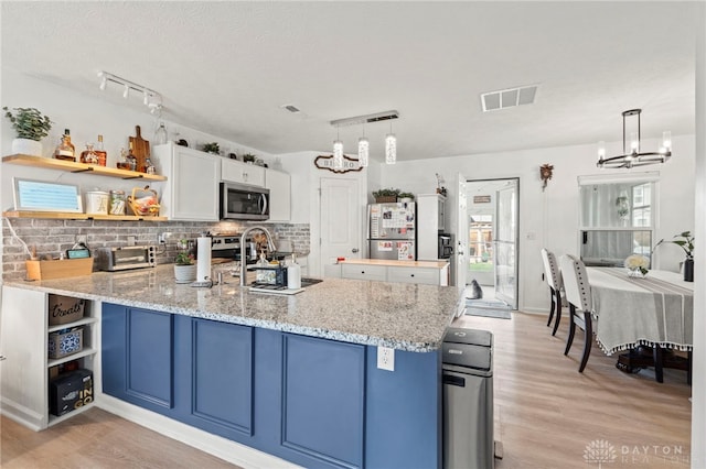 784 Marshall Dr, Xenia, OH 45385 - kitchen featuring open shelves, appliances with stainless steel finishes, a chandelier, light wood-style flooring, and a peninsula