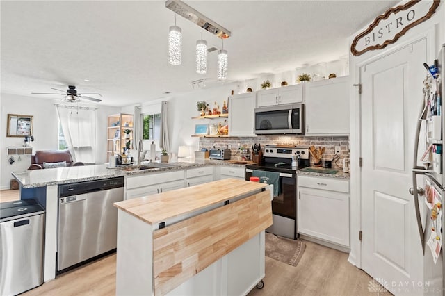 784 Marshall Dr, Xenia, OH 45385 - kitchen with stainless steel appliances, a peninsula, wood counters, light wood finished floors, and tasteful backsplash