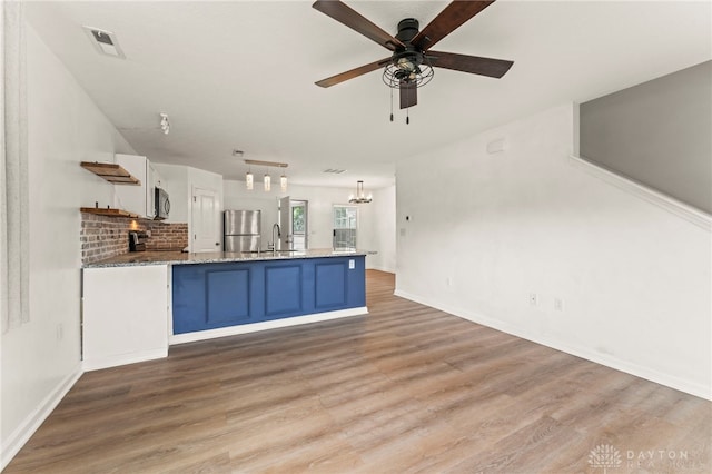 784 Marshall Dr, Xenia, OH 45385 - kitchen featuring freestanding refrigerator, blue cabinets, a peninsula, and light wood-style flooring